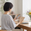 スマートフォンとカードを手にデジタルギフトを準備する女性