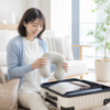 明るいリビングで旅行用ネックピローとスーツケースを準備する女性