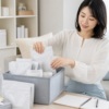 明るいリビングで非常用トイレ用品を収納ボックスへ準備する女性