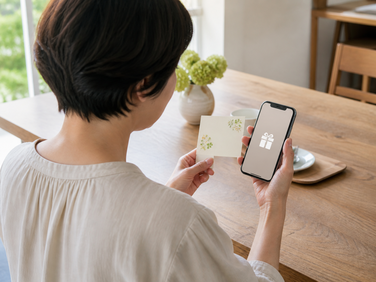スマートフォンとメッセージカードを確認する女性の後ろ姿