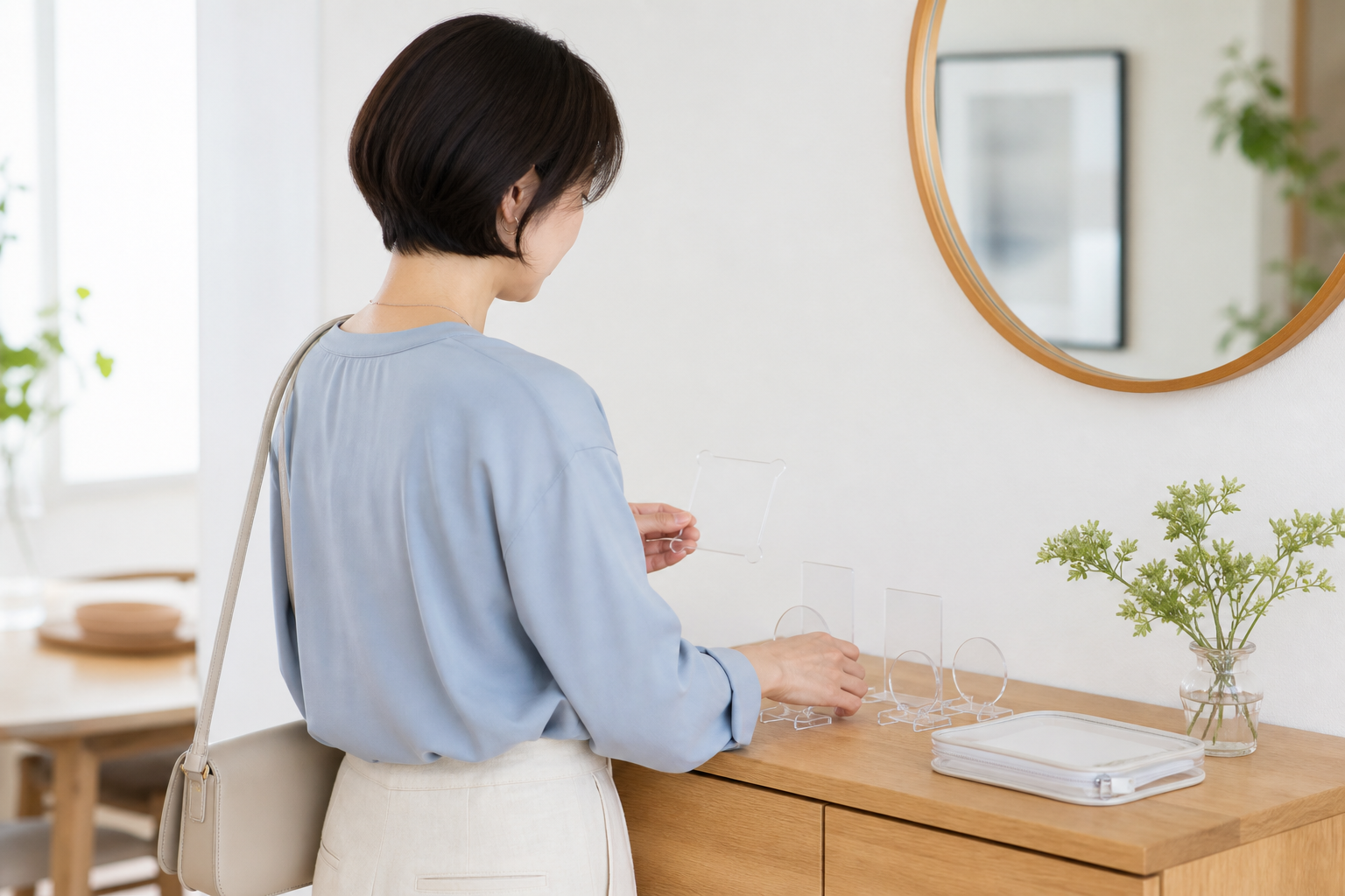 薄型ケースと小さなバッグを並べて持ち運ぶアクリルスタンドを選ぶ女性