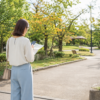 初秋の公園入口で午後のひとり時間を計画する女性