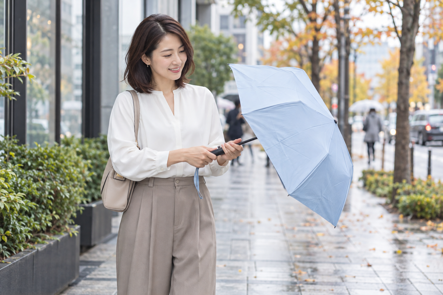 街歩きの途中で晴雨兼用の折りたたみ傘を開く女性