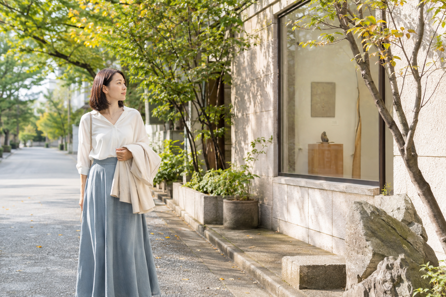 初秋の並木道で小さなギャラリーを眺める女性
