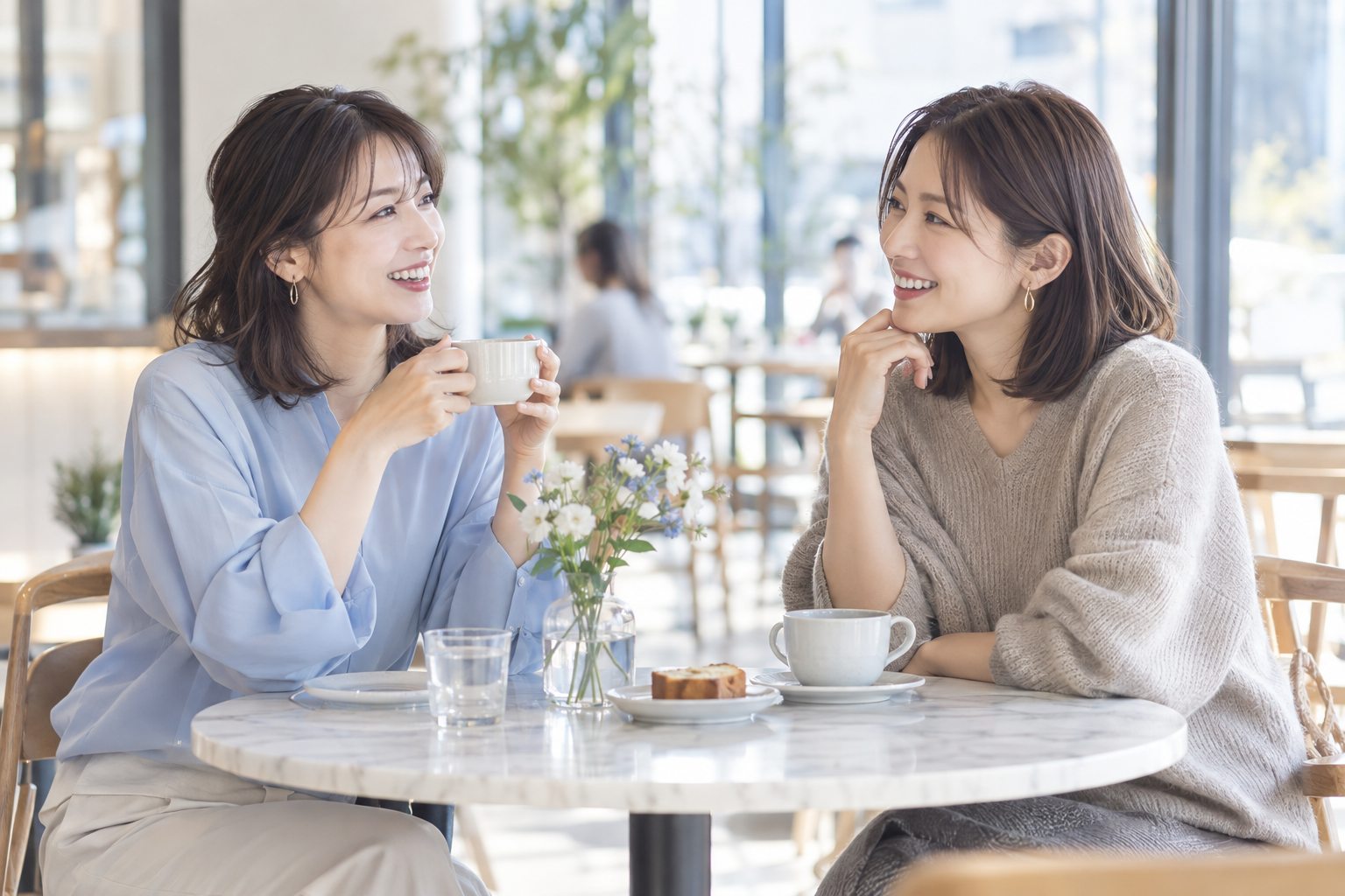 カフェで自然に会話を楽しむ二人の女性