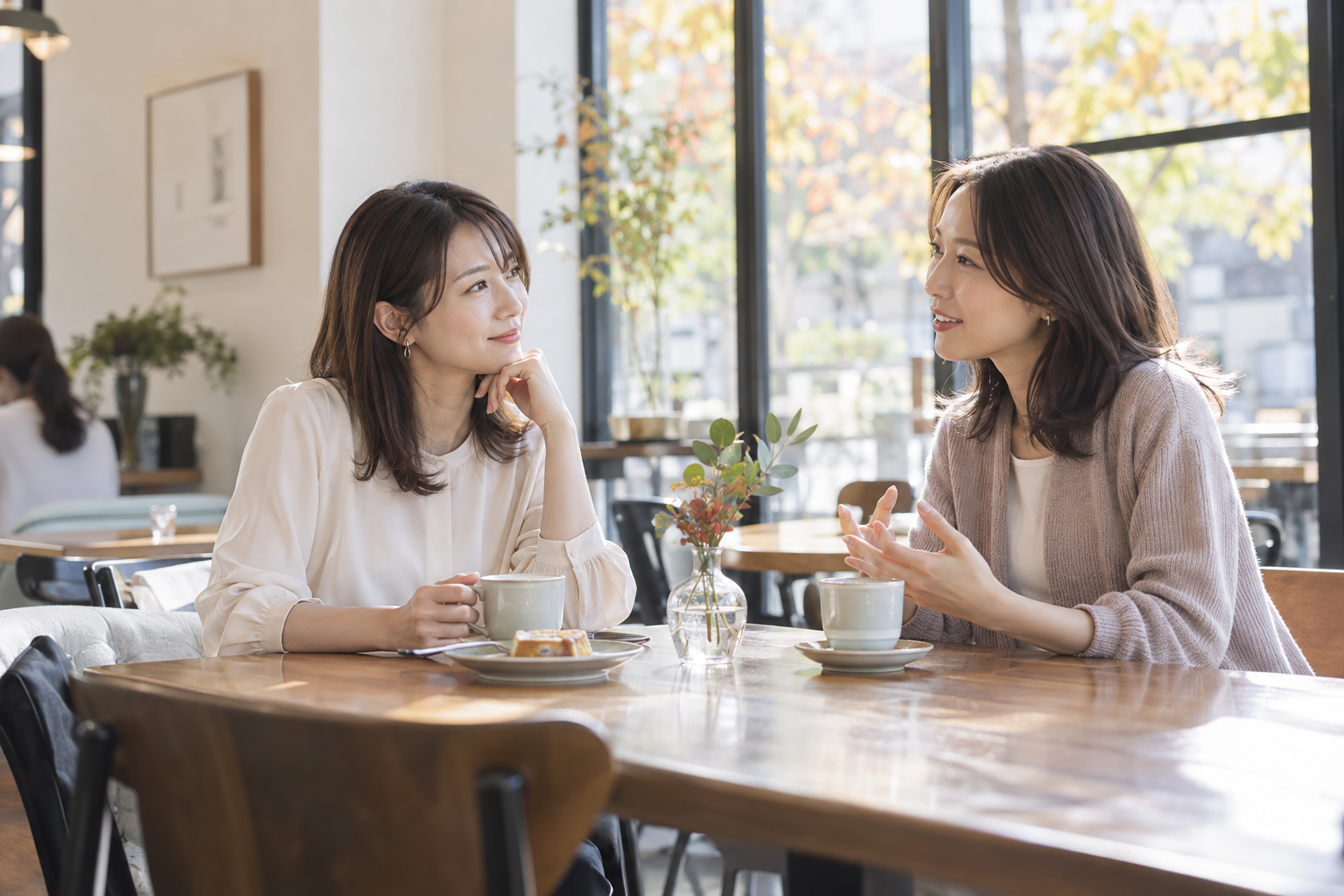 秋の午後のカフェで穏やかに話す友人同士