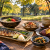 秋の代々木公園で、九州の食をイメージした小皿料理と木のテーブルを上から見た風景